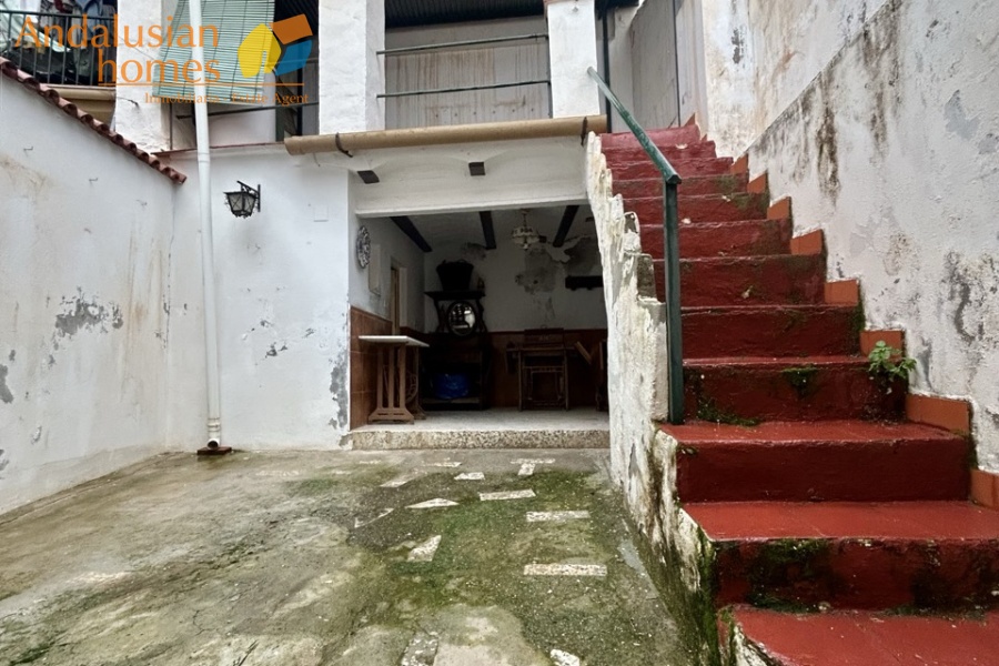 Rear patio with storage space and WC, stairs up to covered terrace